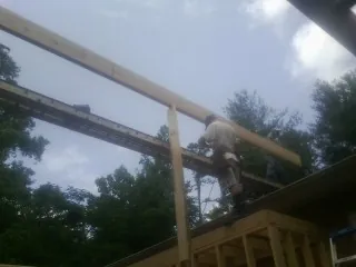 Carpenter setting a ridge beam over a new addition frame — Ice Dam Removal by Roofing Brothers in South Elgin