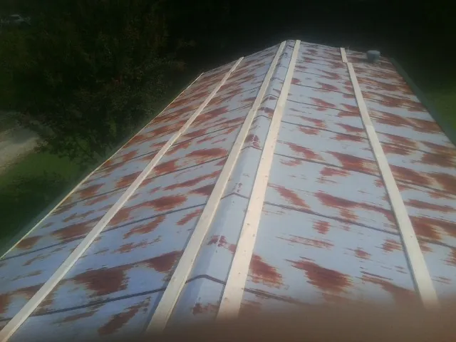 Rusted metal roof panels with new wood purlins before replacement — Storm Damage Roof Repair in South Elgin by Roofing Brothers