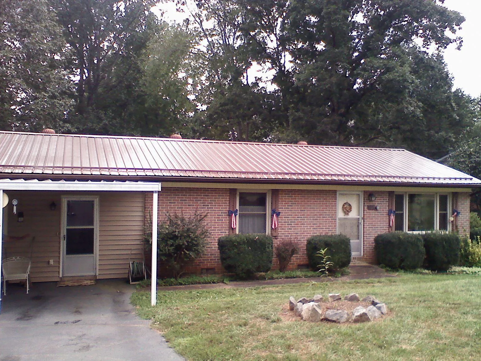 Bronze metal roof and carport on a brick ranch home — Roof Repair work by our crew in South Elgin